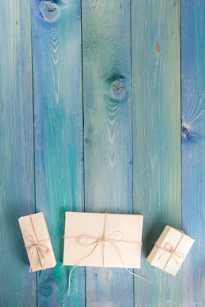 Festive present boxes with ribbon on turquoise painted wooden background. Place for text. Selective focus.