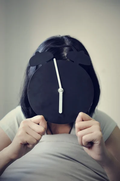 Happiness time of asian woman with an alarm clock on her face.