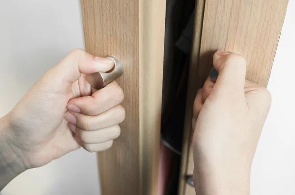 Closeup Hands of woman is holding on door handles