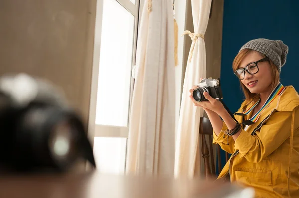 Indoor portrait of Asian pretty woman holding the camera