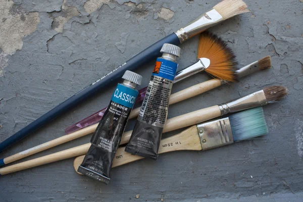 MILAN, ITALY, AUGUST 17, 2015: Brushes and oil color tubes, on grunge background