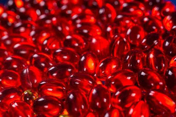Red medical capsules on a mirror surface