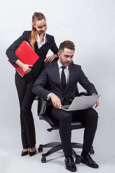Young creative businesswoman sitting on a chair with a laptop on
