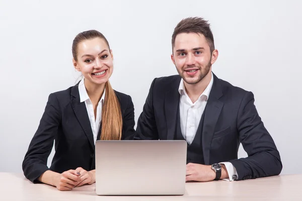 Team of young business man and a woman sitting at computer and l