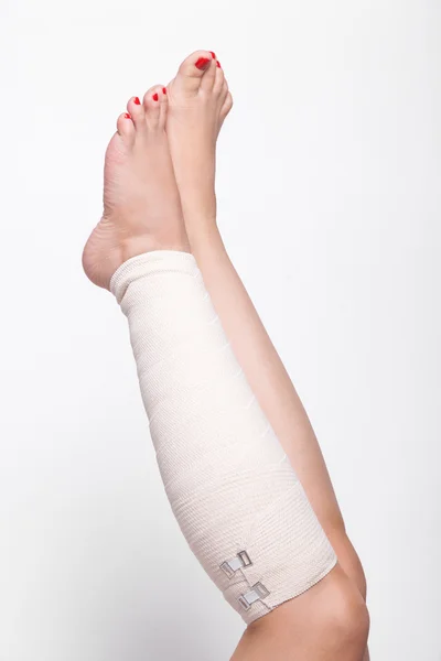 Ankle woman on a white background dragged elastic bandage