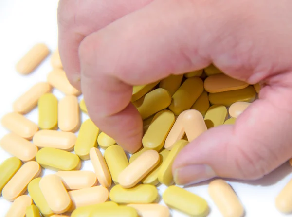 Human hand grab vitamin pills isolated
