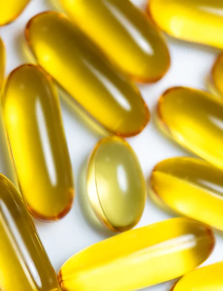 Fish oil and food supplement pills macro vertical