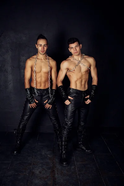 Two young muscular men black background