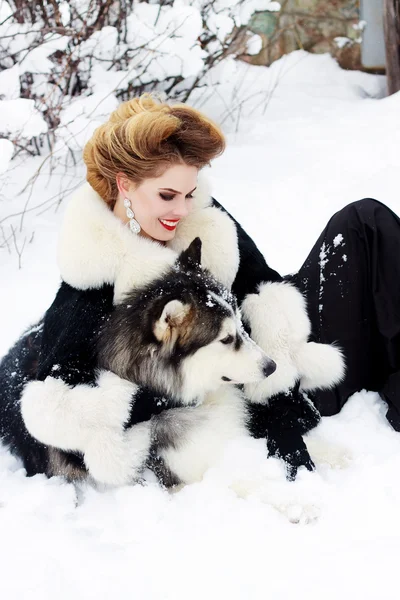 Young woman with wolf dog in snow