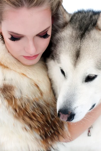 Young woman with wolf dog in snow