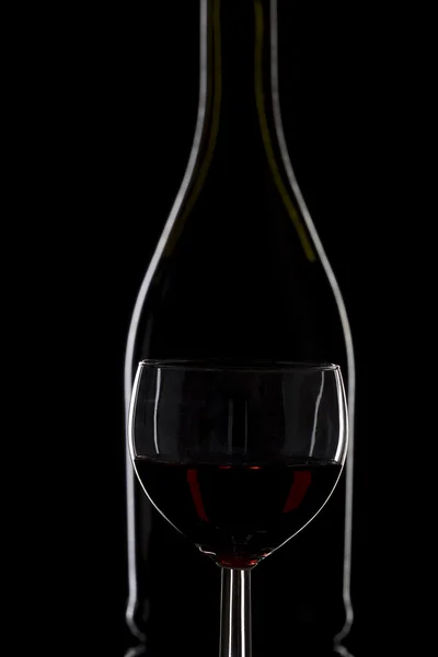 Bottle of wine and a glass of wine on a black background, minima