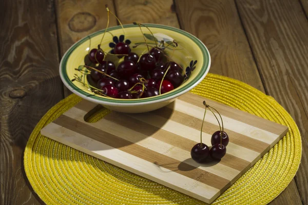 Berries cherries in a bowl on a wooden background.