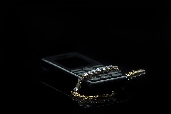Jewelery with a cell phone on gradient dark background