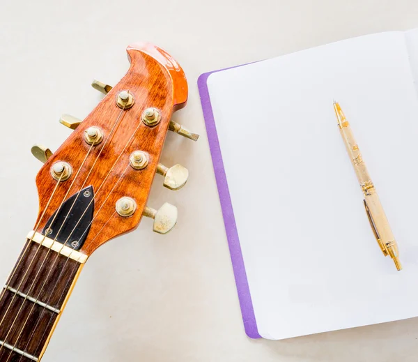 Guitar, notebook, pen and space for write message