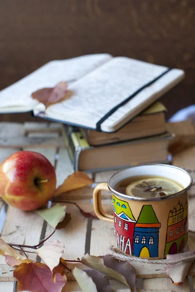 Book, notebook and cup of hot tea