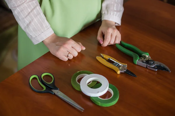 Florist tool in the hands of a woman making a bouquet