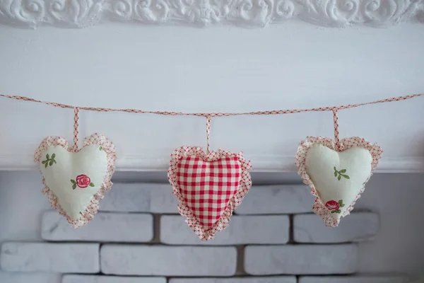 Cloth hearts hanging on the wall on a rope