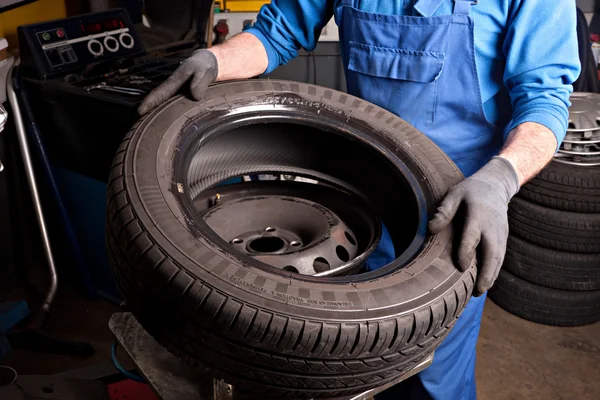 Mechanical repairs a tire in the garage.