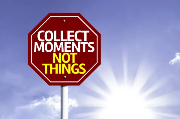 Collect Moments Not Things written on red road sign