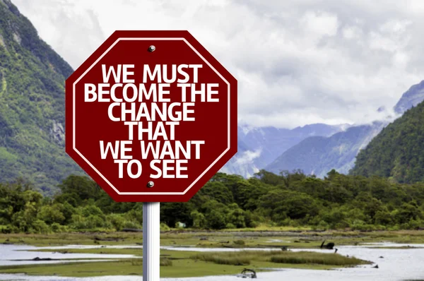 We Must Become The Change That We Want to See written on red road sign