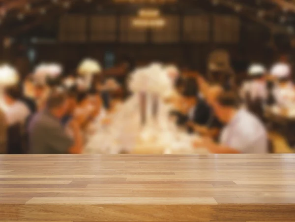 Empty wooden table and blurred dinning people background