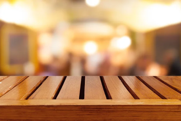 Empty wooden table and blurred cafe background