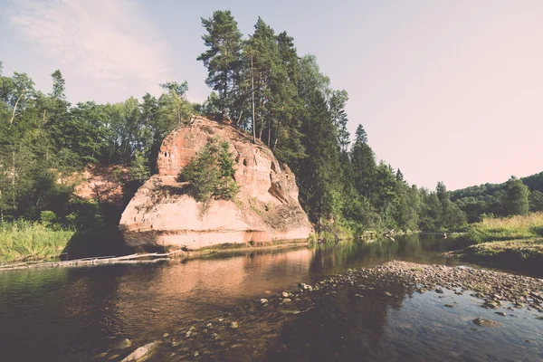 River with reflections in weater and sandstone cliffs - retro, v