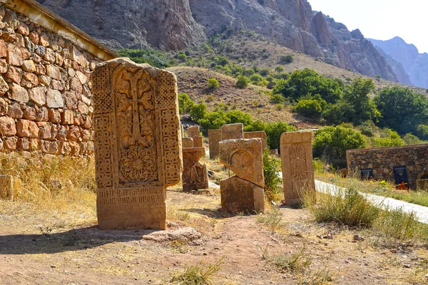 Cross-stone at Noravank monastery in Armenia, red rocky mountains.