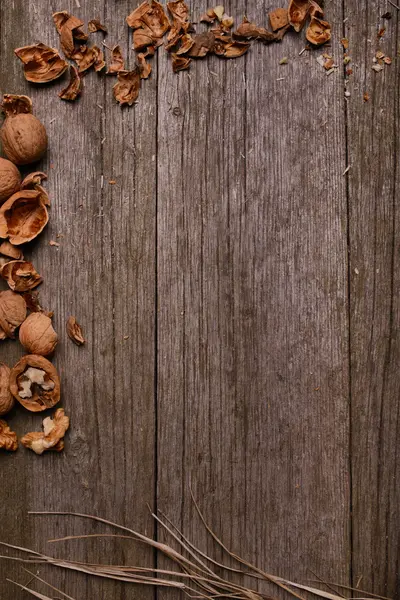 Walnuts on rustic wooden board background with straw copy space for text