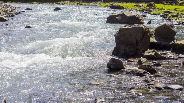 Rock in river with water splashes