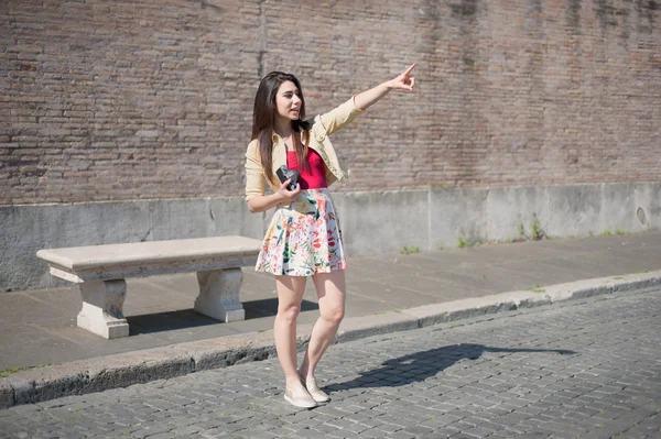 Young woman tourist pointing out outdoor