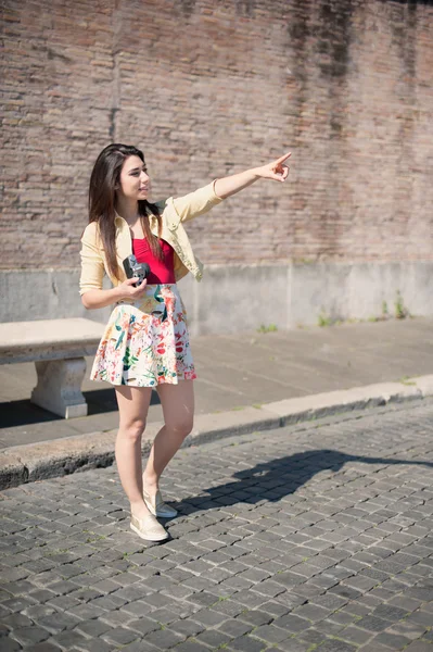 Young woman tourist pointing out outdoor