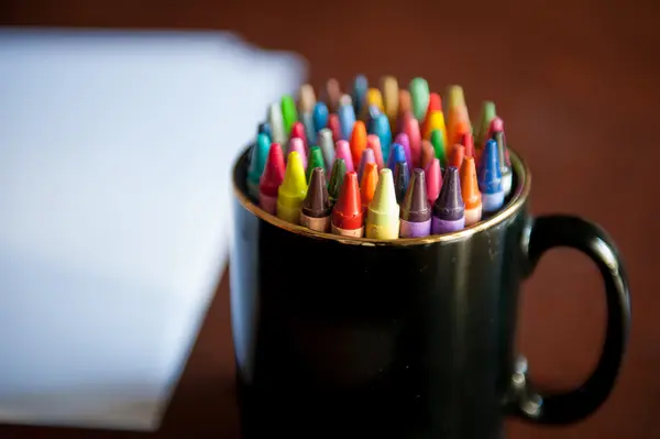 Colorful crayon pencils in a pen tray