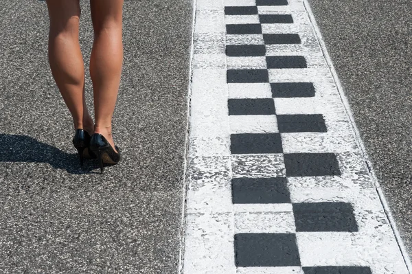 Woman sexy legs on motorsport asphalt track