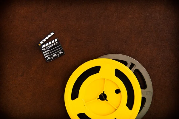 Movie clapper board detail and colored film reels