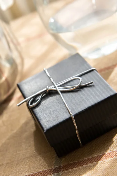 Small gift box with a silver bow in morning sunlight