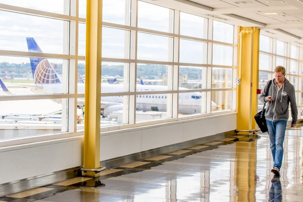 Passengers walking through a bright airport