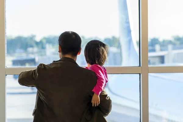 MSY, man and child looking out window at airplane