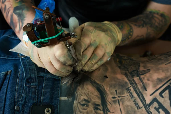 Working hands of tattoo master