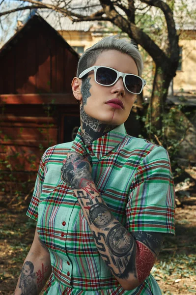 Portrait of tattooed Female with white Sunglasses, unbuttoned he