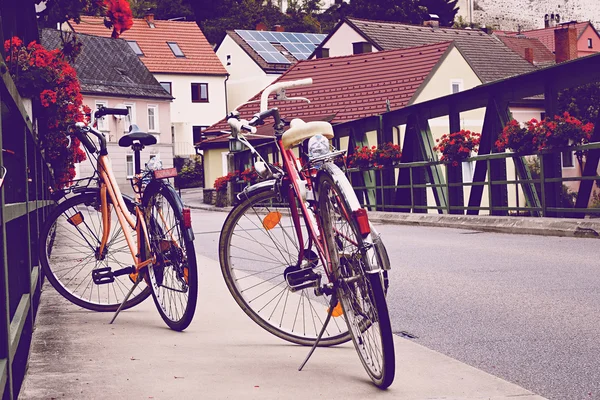 Two old bicycle on the bridge in vintage tinting. Romantic urban landscape in a small European town in Austria.