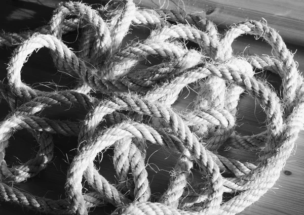 Vintage toned image of hank large ship\'s rope on the background of a wooden table.
