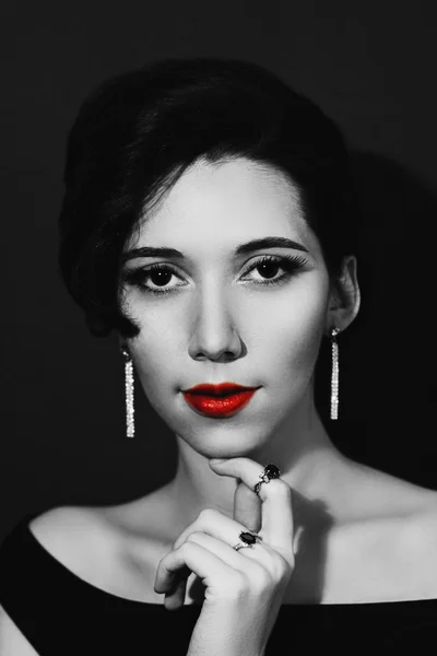 Portrait of a young beautiful woman in black and white colors. Girl in jewelry in the style of 1920s.