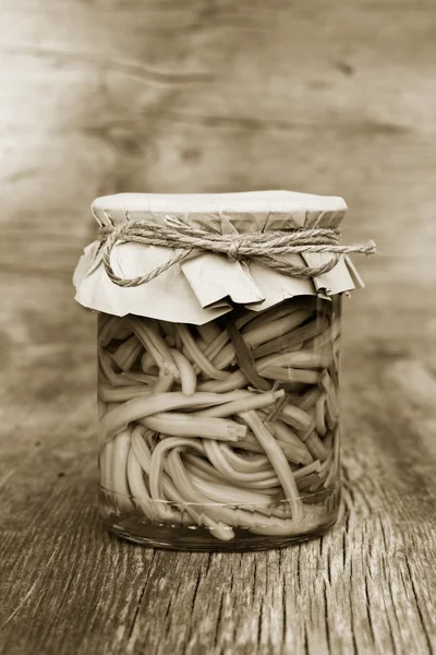 Pickled garlic sprouts in glass jar closeup. home canning. black and white photo