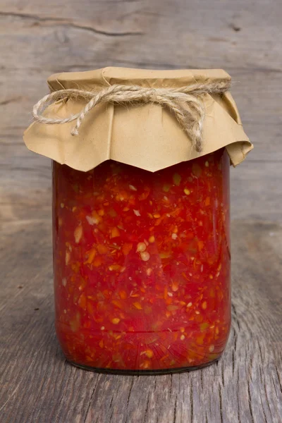 Red tomato sauce with sweet pepper in glass jar closeup. home canning
