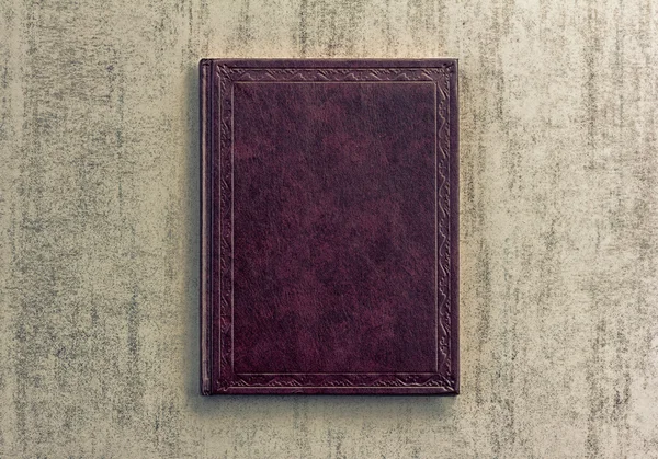Purple book on a grey grunge background, top view, retro toned image