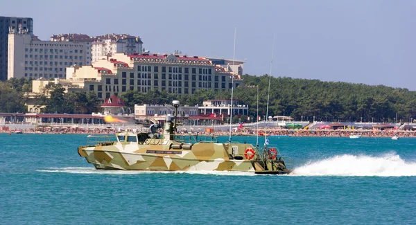 Military boat at full speed makes blank volley of guns on the city beach