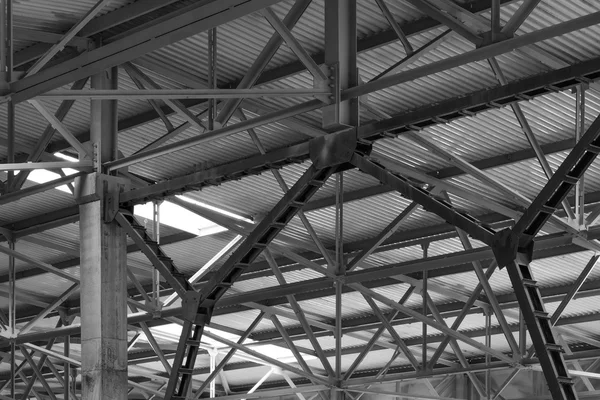 Metal framework of the roof of industrial premises in the enterprise inside view in black and white