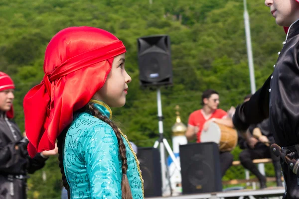 Portrait of a young dancer in traditional Indian dress on the background of the scene, the temple and the green hill. Ethnic festival in the foothills of the Western Caucasus in Adygea