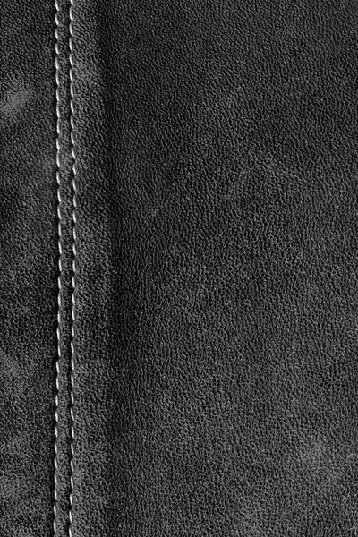 Texture of natural leather with stitching. Free space for text. Copy space. Black and white photo